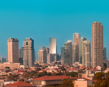 Modern buildings in city against clear blue sky
