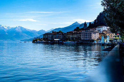 Scenic view of lake by buildings against sky