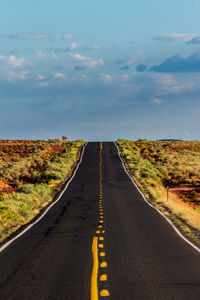 Empty road along countryside landscape