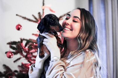 Smiling young woman with dachshund puppy