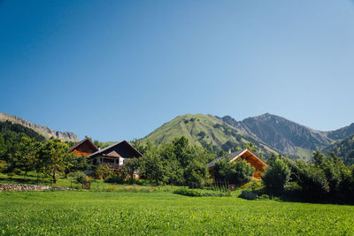 Scenic view of mountain chalets in summer. a mountain village. scenic view of field and houses