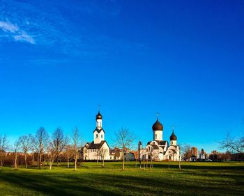 Built structure on field against clear blue sky