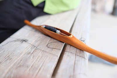 Close-up of thread in wooden equipment on table