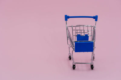 High angle view of empty deck chairs against pink background