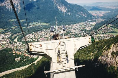 Man at overhead cable car station against mountain