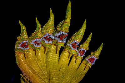 Close-up of dragon sculpture against black background