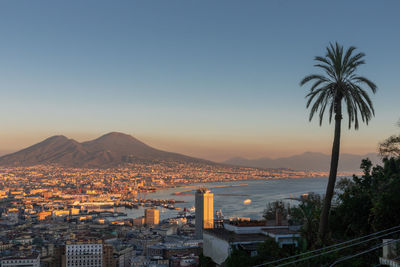 City by sea against sky during sunset