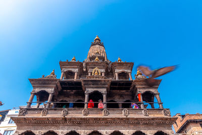 Low angle view of temple building against blue sky