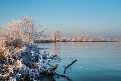 Scenic view of lake against sky during winter