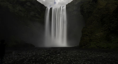 Scenic view of waterfall against sky