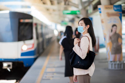 Woman standing on train at railroad station