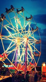 Low angle view of illuminated ferris wheel against sky