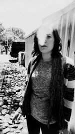 Portrait of young woman standing on railroad track