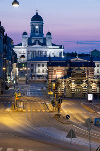 View of city street and buildings at dusk