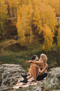 Happy people in love are travel hike in nature in the autumn forest. romantic trip to countryside