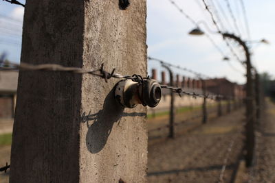 Close-up of barbed wire on fence against sky