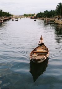 Boat moored in lake against sky