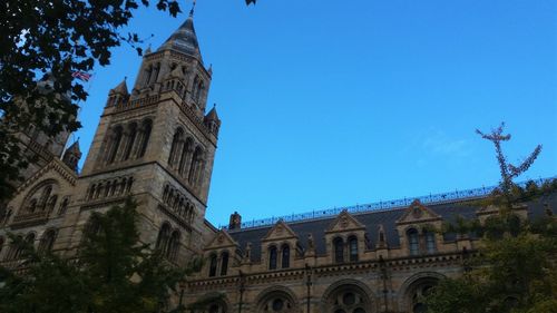 Low angle view of clock tower against blue sky