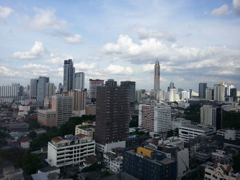 Aerial view of buildings in city against sky