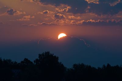 Low angle view of silhouette trees against romantic sky