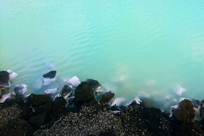 High angle view of rocks in sea against sky