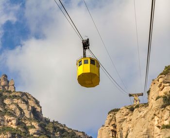 Low angle view of overhead cable car against sky