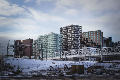 Buildings in city against sky during winter