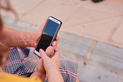 Close up of a middle aged woman and her mother holding a smartphone