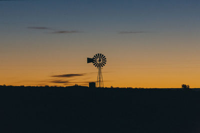 View of silhouette windpump against sky during sunset