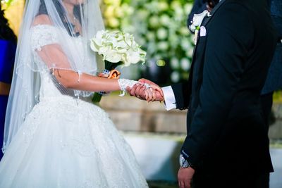 Midsection of couple holding hands