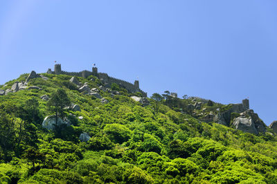 Castle of the moors on mountain against clear blue sky