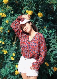 Young woman standing by flowering plants