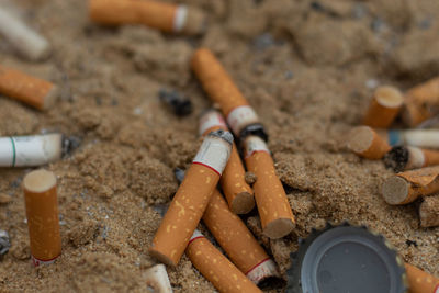 High angle view of cigarette butts on dirt