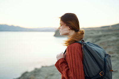 Rear view of woman looking at mountain against sky