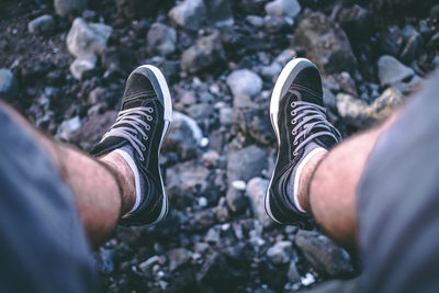 Low section of man in shoes over rocks