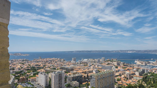 High angle view of townscape by sea against sky