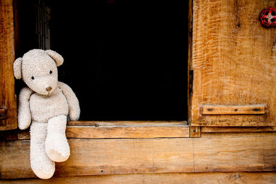 Close-up of stuffed toy on wooden window