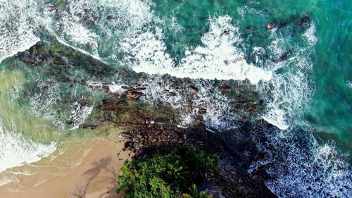 High angle view of sea waves splashing on rocks