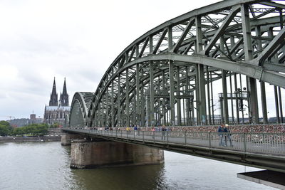 Bridge over river by building against sky