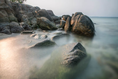 Rocks in sea against sky