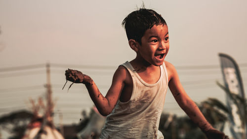 Portrait of boy standing against sky