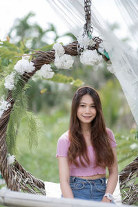 Portrait of young woman standing against blurred background