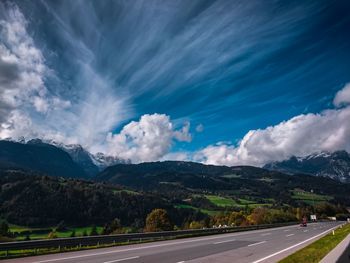 Road leading towards mountains against sky