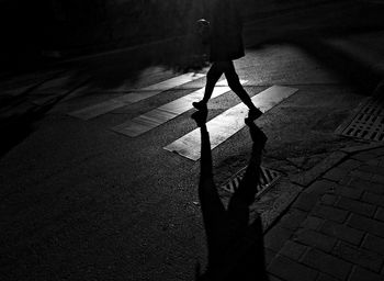 Low section of man walking on street