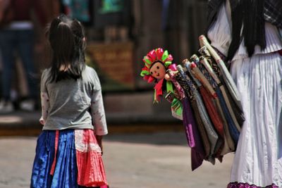 Rear view of women walking on street in city