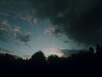 Silhouette of trees against cloudy sky