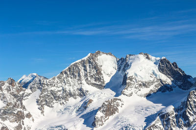 Scenic view of snowcapped mountains against blue sky