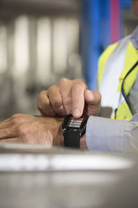 Man using smartwatch in industrial plant