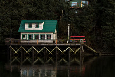 View of house by lake against trees