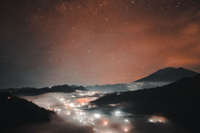 Scenic view of silhouette mountains against sky at night